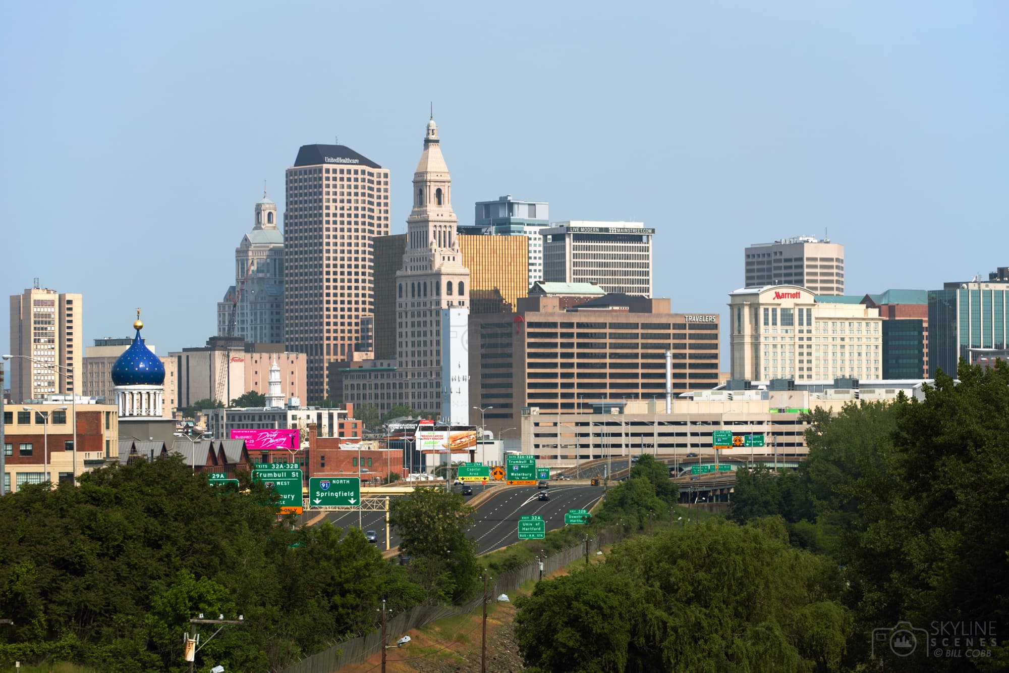 Hartford, Connecticut skyline featuring the Travelers Tower and blue dome above a highway.